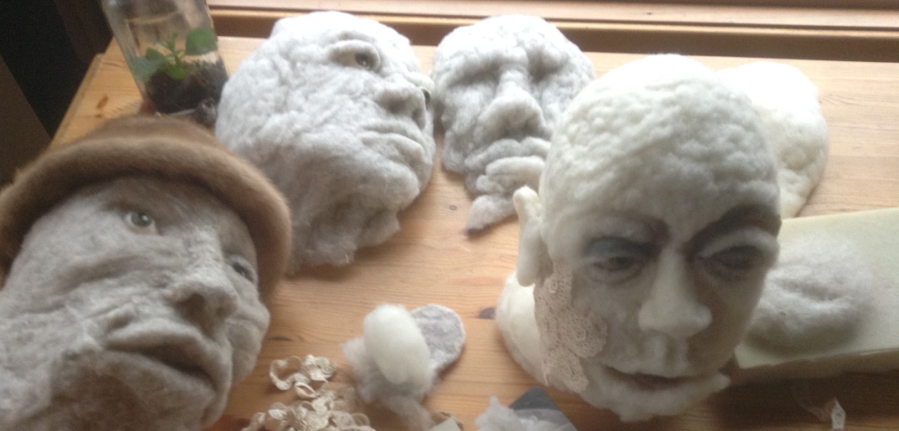 Four different wool heads in various stages of creation on artist Rosemarie Péloquin's work table.
